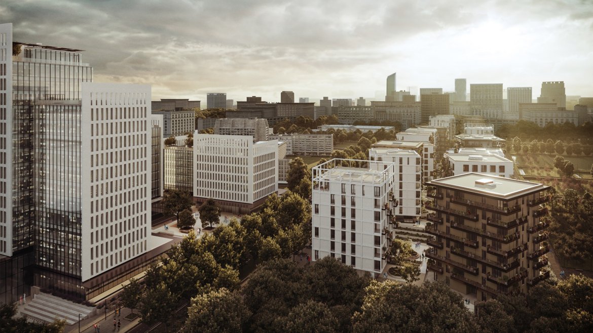 Vista di un moderno complesso residenziale con edifici bianchi e grigi circondati da alberi, con una città sullo sfondo e un cielo nuvoloso.